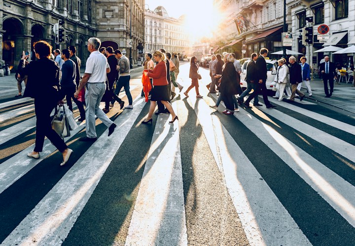 Menschen überqueren einen Fußgängerüberweg – Symbolfoto zu sicheren Fußwegen und Schulwegen